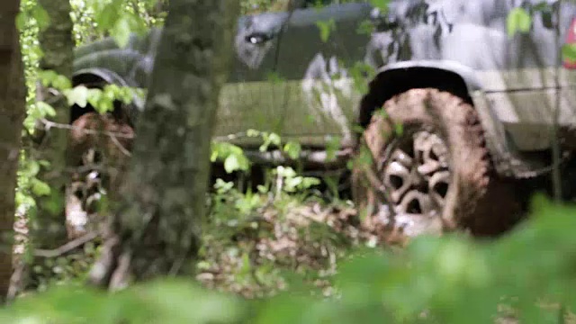 探险越野车在肮脏的道路上缓慢地穿过树林。视频素材