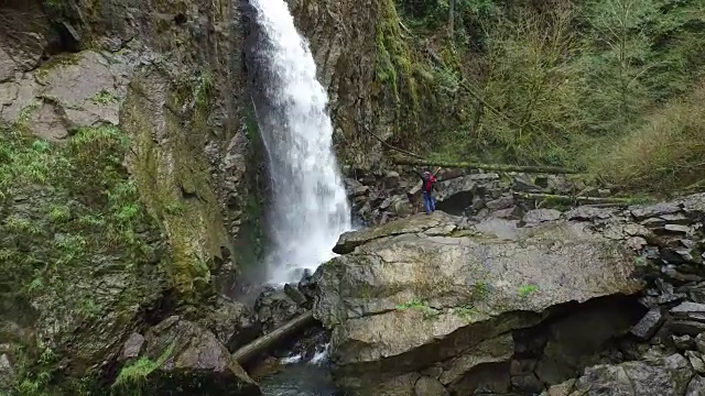 背包客爬岩石去瀑布视频素材