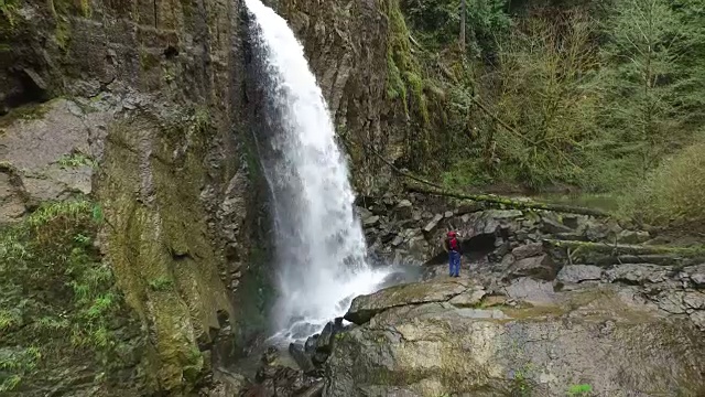 航拍背包客站在瀑布前视频素材