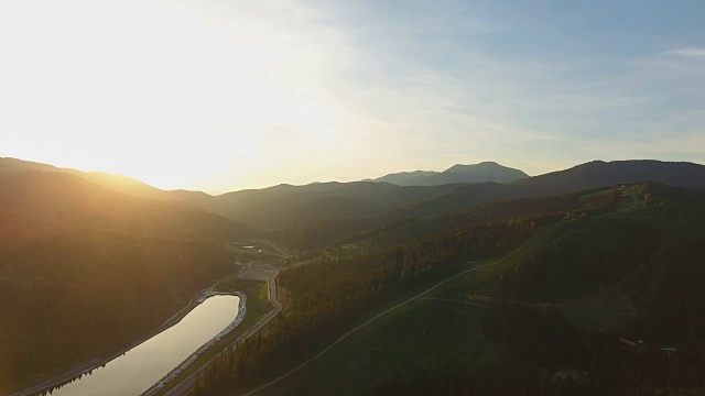 鸟瞰图。在夕阳中飞过美丽的山河。航空摄影机镜头。景观全景。乌克兰,喀尔巴阡山山脉。Bukovel视频素材