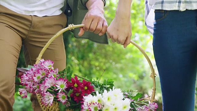 中间的一对夫妇抱着装满鲜花的篮子视频素材