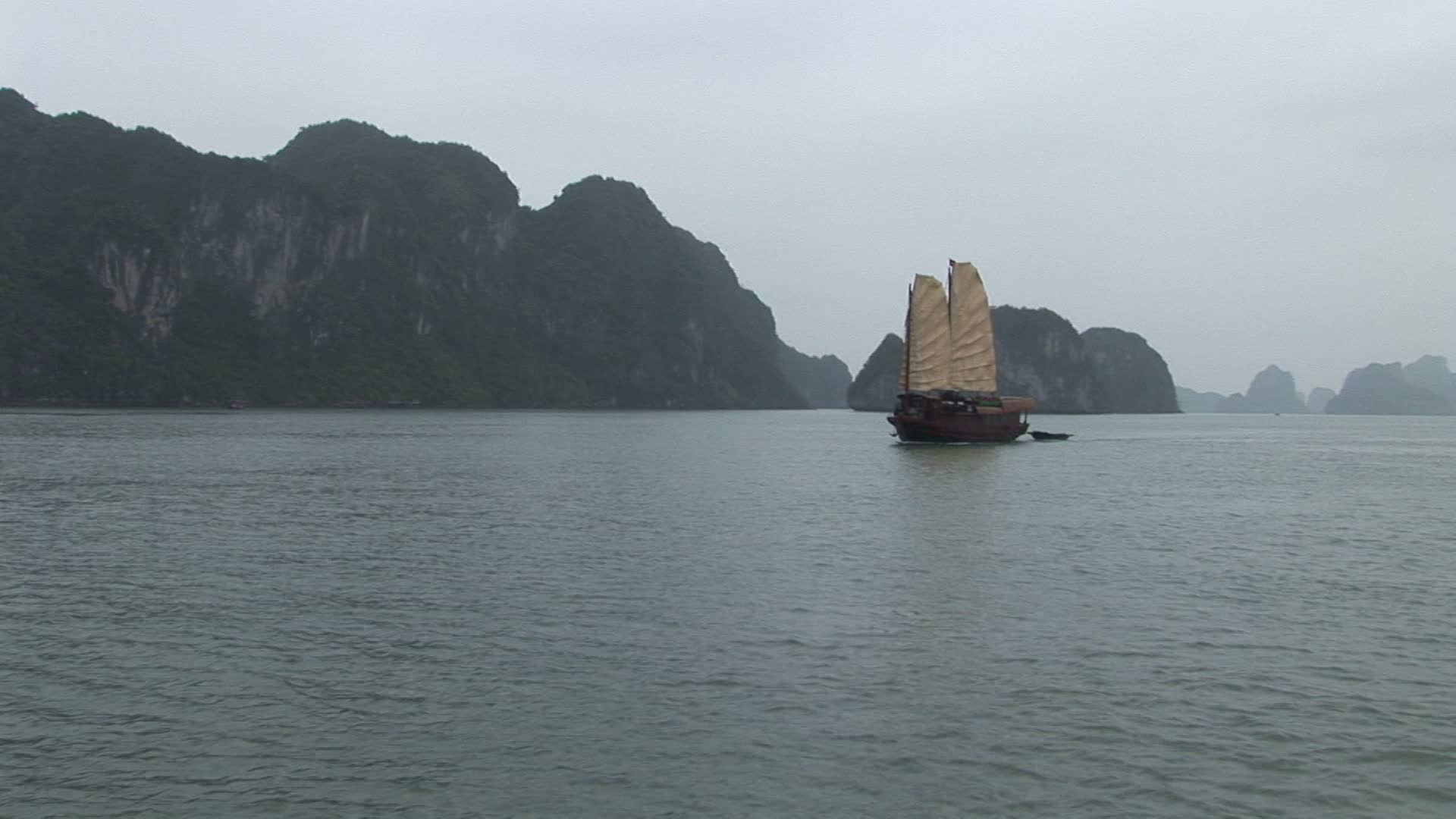 越南下龙湾。从一艘正在移动的船上看到的一艘舢板视频素材