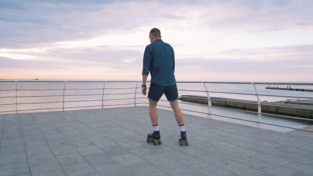 一个年轻的白人男子在海边滑旱冰鞋，慢镜头视频素材