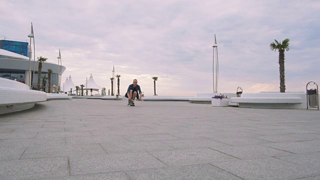 一个年轻的白人男子在海边滑旱冰鞋，慢镜头视频素材