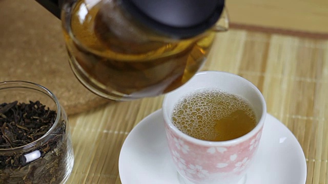 慢动作将茶倒入杯中视频素材