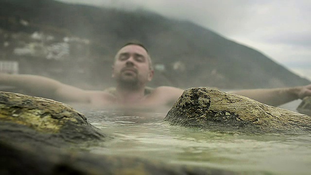 男子在度假村的海滩上洗热矿泉浴视频素材