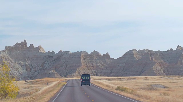 沿着空无一人的道路行驶，把Badlands砂岩山脉抛在了身后视频素材