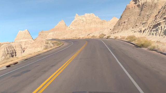 空旷的道路蜿蜒曲折地穿过Badlands令人惊叹的砂岩视频素材