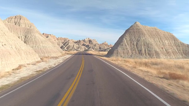 空旷的道路蜿蜒曲折地穿过Badlands令人惊叹的砂岩视频素材