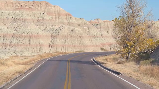 空旷的道路蜿蜒曲折地穿过Badlands令人惊叹的砂岩视频素材