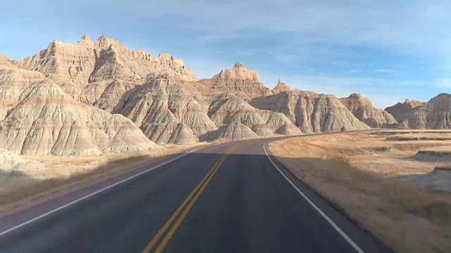 时光流逝:驾车沿着空旷的道路蜿蜒穿过荒地视频素材