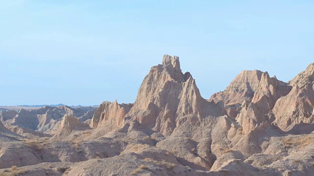 AERIAL:在Badlands NP，陡峭的砂岩山脉映衬着湛蓝的天空视频素材