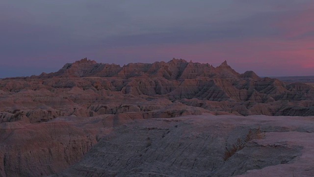 在Badlands国家公园的落基山脉后面美丽的粉红色日落视频素材