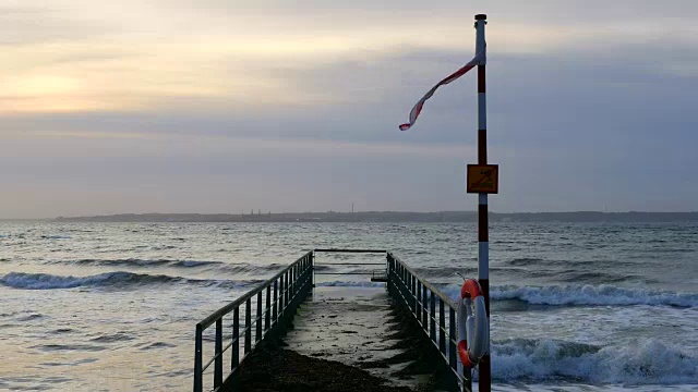 日落时海浪拍打着码头。有风的天气视频素材