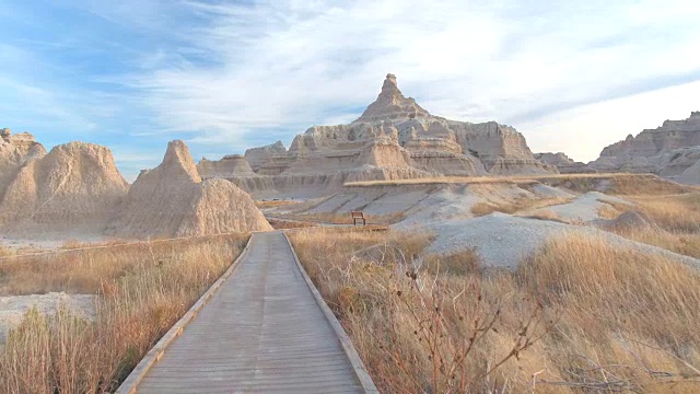 沿着空荡荡的木板路，穿过令人惊叹的Badlands沙漠景观视频素材