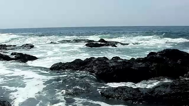 海浪冲刷着夏威夷科纳的黑色熔岩岩石视频素材