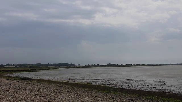 海滩和海岸景色与流水下游的河流，天空，在远处的土地视频素材