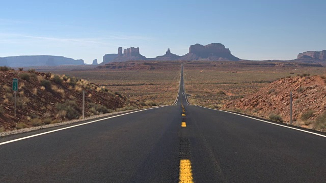 在阳光明媚的美国犹他州标志性的纪念碑谷笔直的道路视频素材