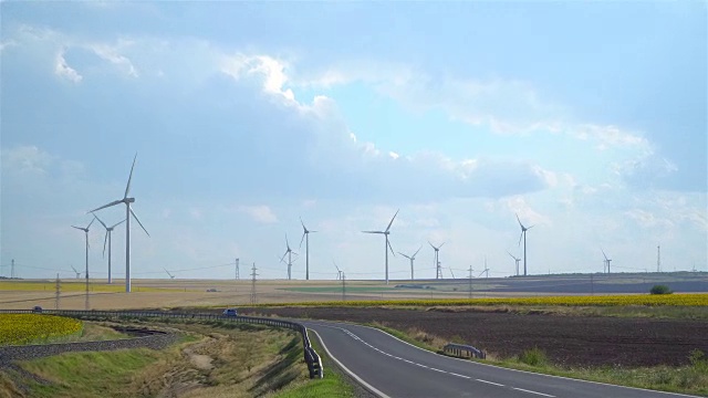 放大的场景。风力涡轮机、高速公路和耕地视频下载