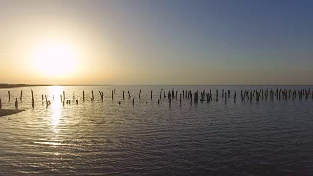 日落时盐湖上被毁的废弃木桥，航拍录像视频素材