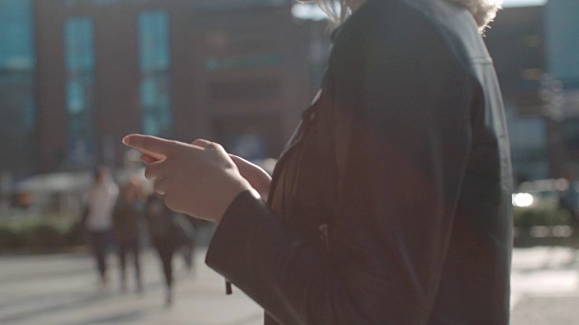 一个年轻的白人女人在城市里打电话。视频素材