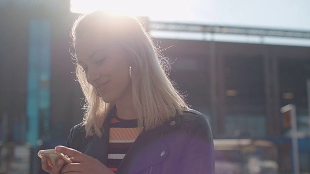 一个年轻的白人女人在城市里打电话。视频素材