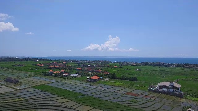 空中飞过稻田和村庄到海滩视频素材