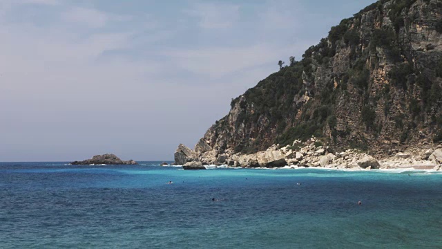 美丽的绿松石蓝色的海浪和海岸景观与山和小岛-暑假背景视频视频下载