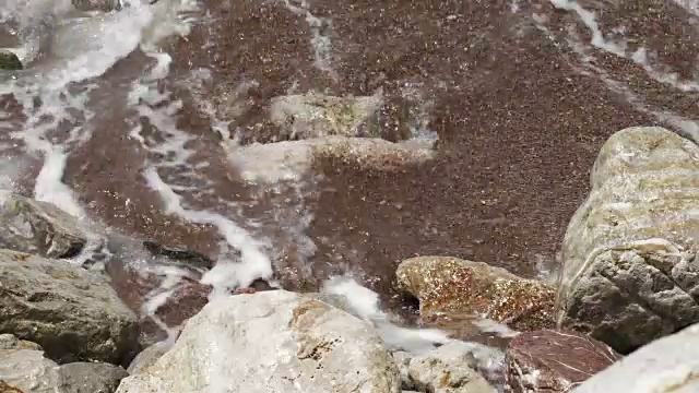 海洋抽象细节特写岩石在海滩溅起的海浪创造大量的海洋泡沫-海洋抽象背景4k视频视频下载