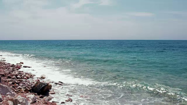 美丽的一天在海滩上与海浪拍打在岸边的岩石-自然景观背景4k视频视频下载