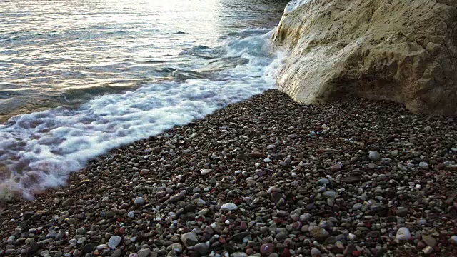 海浪撞击白色的岩石在沙滩上的沙子，石头和鹅卵石慢动作-海景背景视频素材