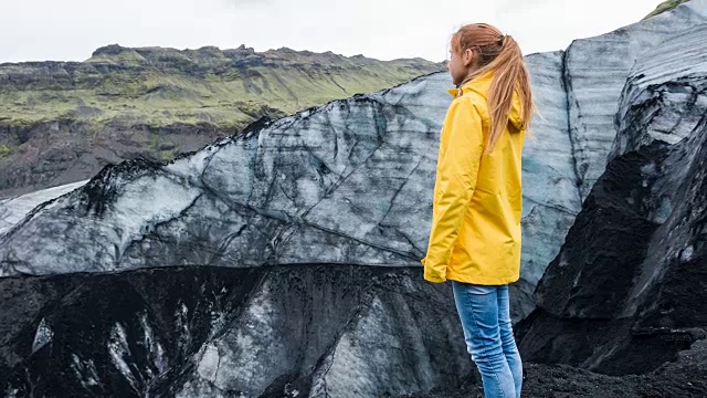 女游客欣赏被火山灰覆盖的冰岛冰川视频素材