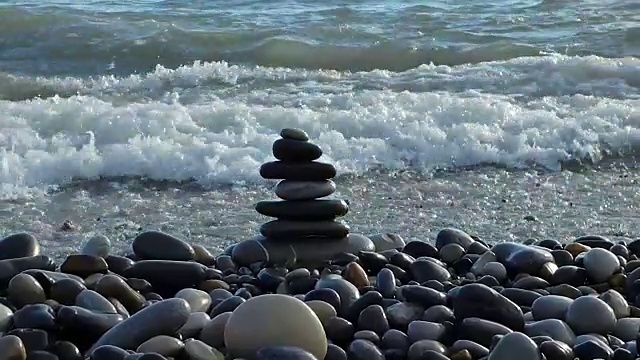 海滩上被海浪拍打的禅宗石视频素材