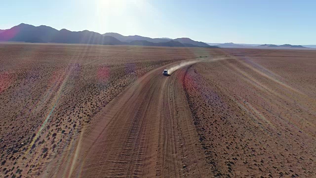 鸟瞰图的旅游车辆行驶在沙砾道路在纳米比亚的沙漠视频素材