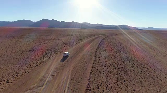 鸟瞰图的旅游车辆行驶在沙砾道路在纳米比亚的沙漠视频素材