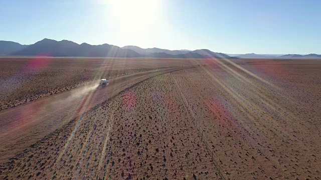 鸟瞰图的旅游车辆行驶在沙砾道路在纳米比亚的沙漠视频素材