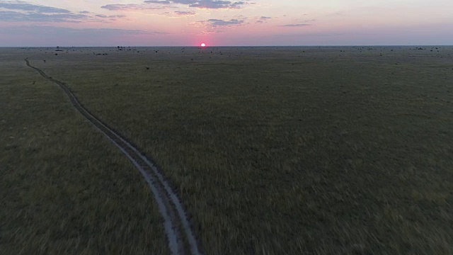 鸟瞰图的泥土路通过草原的博茨瓦纳走向夕阳视频素材