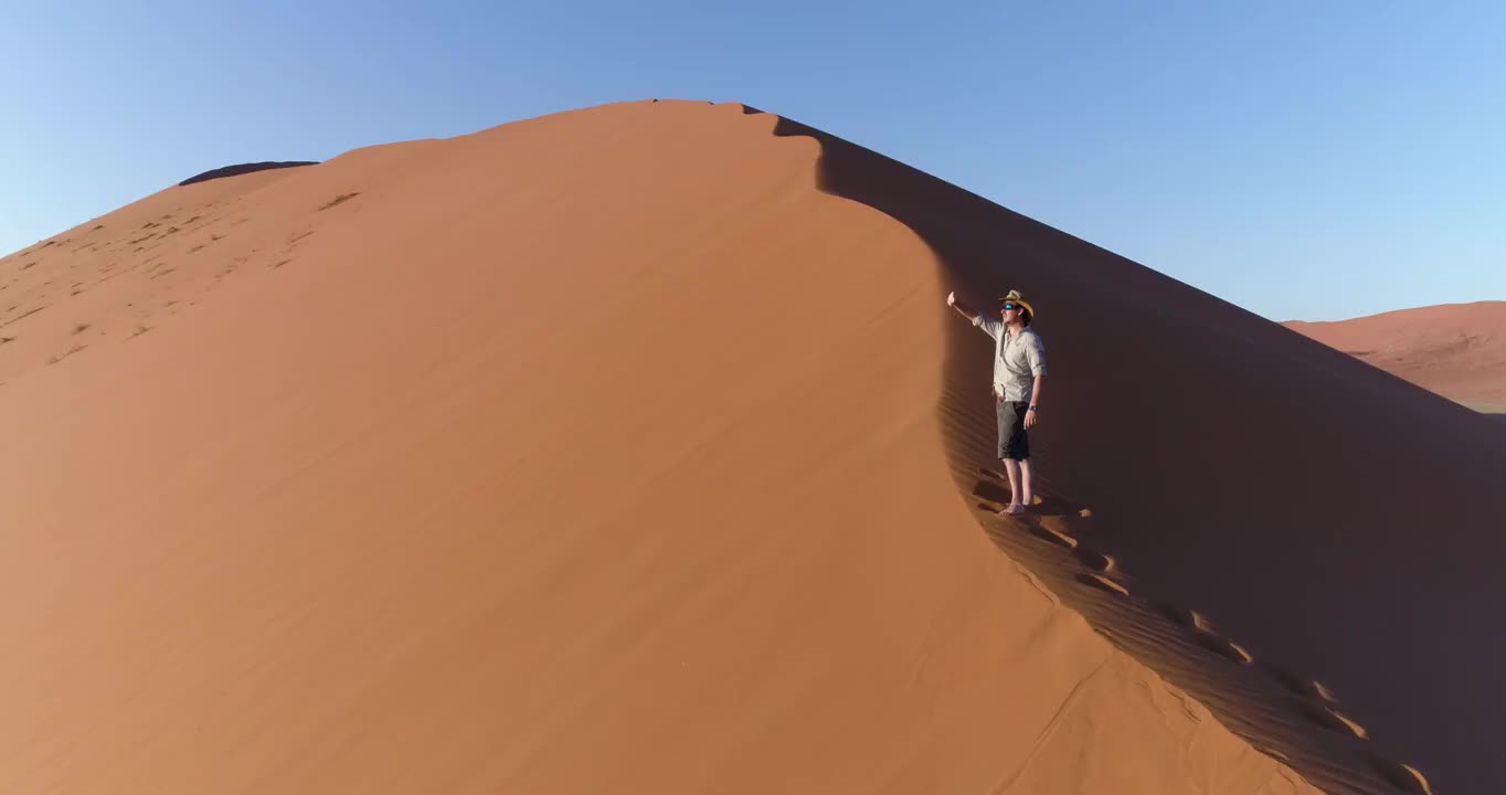 鸟瞰图的男性游客在壮观的观点，巨大的沙丘在纳米布沙漠视频素材