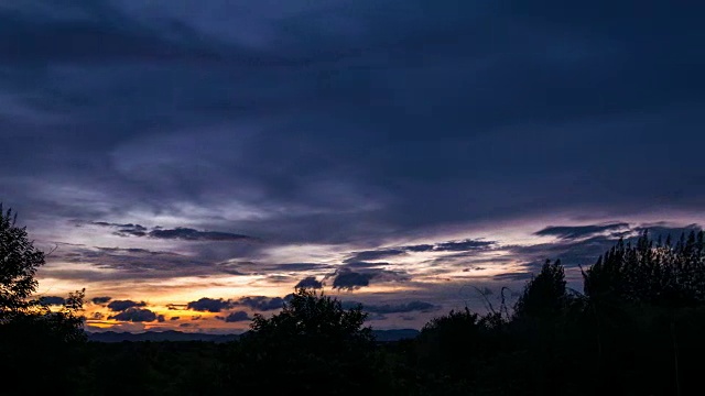 黄昏时，树和山上的云的流逝视频素材