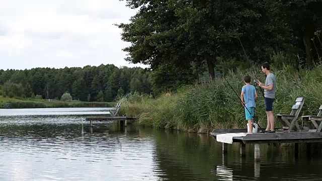 放松的父子在淡水湖钓鱼视频素材