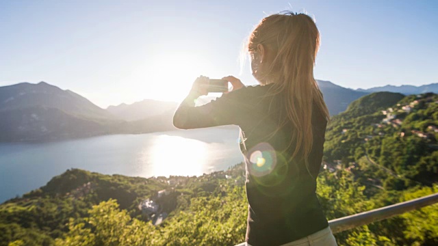 女人拍摄的湖和湖滨村庄的全景照片视频素材