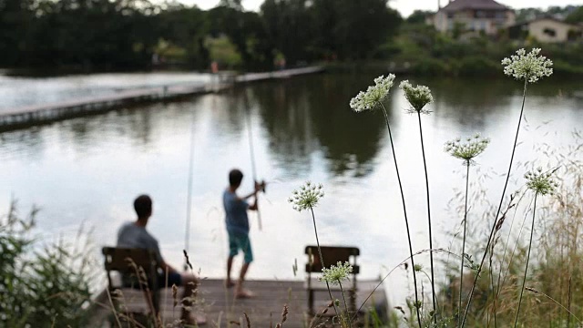 少年在平静的湖面上钓鱼视频素材