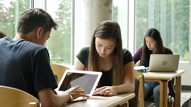 女学生在桌子前学习时看着相机视频素材