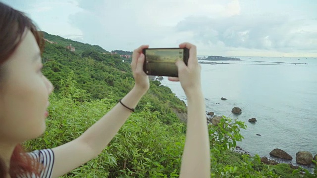 在海滩上拍照的女孩视频素材