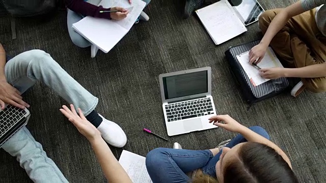 学生们在地板上一边学习一边交谈视频素材