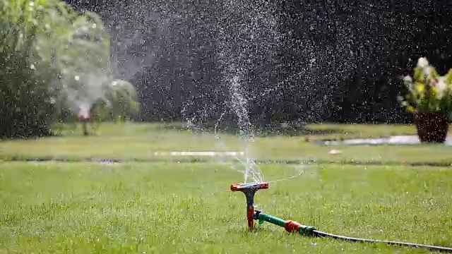 两个花园洒水器在浇草视频素材