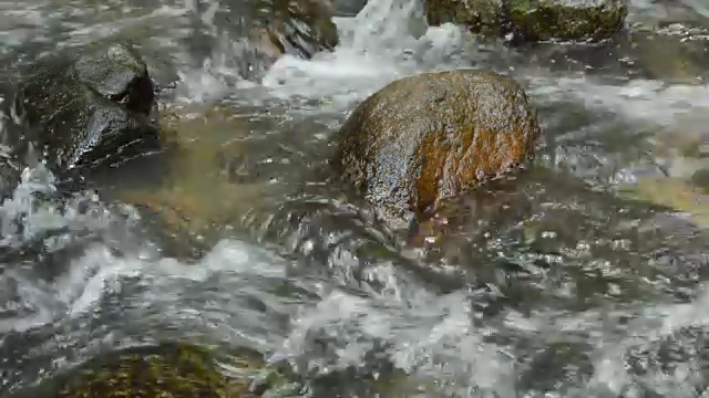 水流击打着岩石，浪花在河里溅起水花视频素材