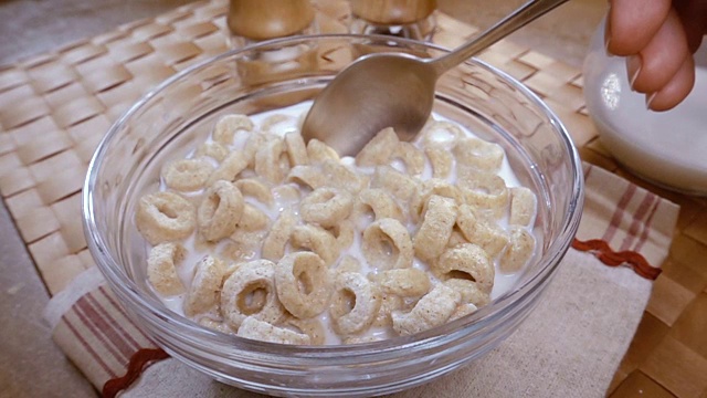 脆燕麦片在碗里，早餐美味的牛奶。慢动作旋转跟踪镜头。视频素材