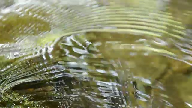 水流打在岩石上，起了涟漪视频素材