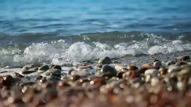 海浪冲刷砾石海滩，微距拍摄视频下载